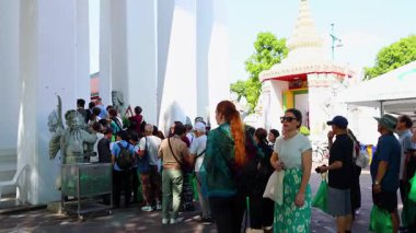 Turistler, Bangkok, Tayland 'daki Wat Pho' da güpegündüz toplandılar. Sahne, kültürel keşifleri ve canlı mimariyi yakalıyor.