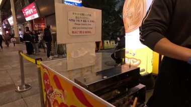 Sokak satıcısı müşteriler için peynirli krep hazırlar..