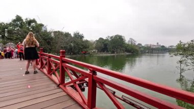 Hanoi 'de kırmızı bir köprüde yürüyen insanlar.