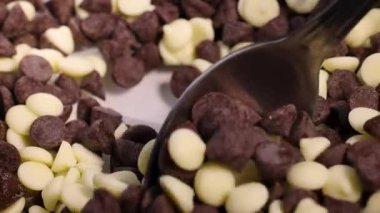 Kaşıklar siyah ve beyaz çikolata parçalarını harmanlarlar.