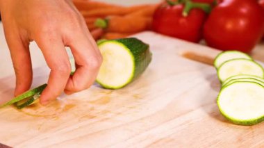 Masada salatalık kesen kadın, yakın plan. Sağlıklı bir yaşam için salata hazırlıyorum.