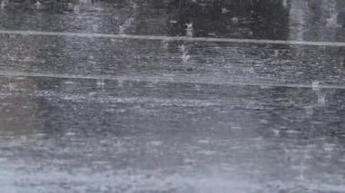 Islak bir yüzeye sağanak yağmur yağıyor