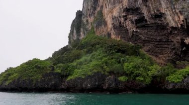 Tur teknesi Krabi 'deki yemyeşil kaya adalarından geçiyor.