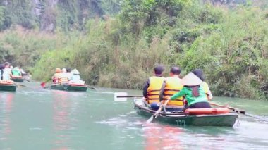 Manzaralı bir nehirde kürek çeken insanlar