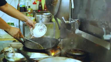 Şef sıcak tavada erişte hazırlar.