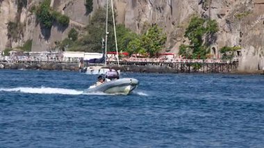 Bir sürat teknesi Sorrento kıyısı boyunca seyahat ediyor.