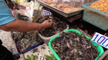 Sokak pazarında yengeç organize eden kişi