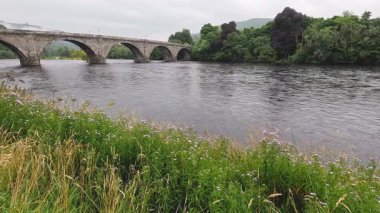 Tarihi bir taş köprüsü olan sakin bir nehir.