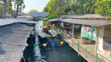 Dalgalı yüzen bir pazarda tekneler ve tezgahlar