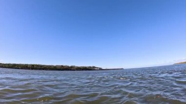 Dalgalar ve ufuk açık mavi gökyüzünün altında