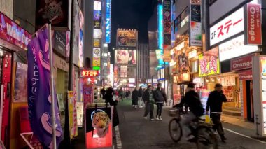 Canlı, aydınlık bir şehir caddesinde yürüyen yayalar.