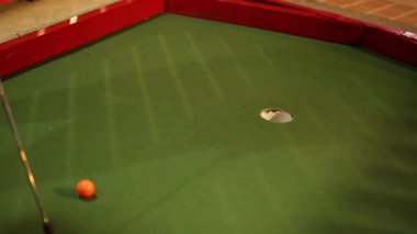 Mini golf vuruşu denendi ama ıskaladı. Sahne kırmızı kenarlı yeşil bir rotaya ayarlandı.