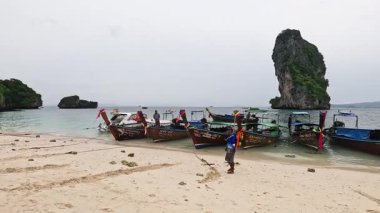 Tayland sahilinde tekneler ve insanlar.