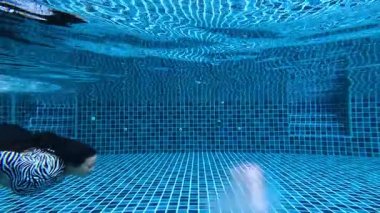 Kiremit havuzunda suyun altında yüzen kişi