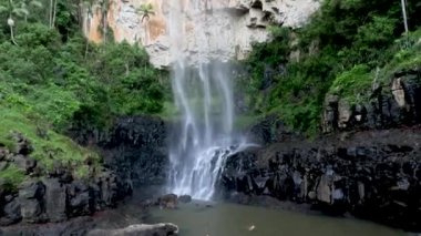 Şelale kayalık bir uçurumdan aşağı yuvarlanıyor.