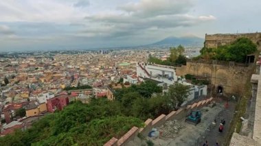 Uzak dağları ve bulutlu gökyüzü olan manzaralı bir şehir.