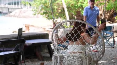 Bir kadın Sarasin Köprüsü 'nün yakınlarındaki salıncakta huzurlu bir anın tadını çıkarıyor, doğal ışıklandırma ve sakin bir zemin ile.