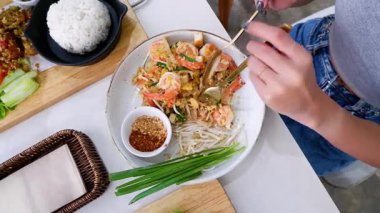 Karidesli Asya yemeği yiyen bir kadının yakın plan görüntüsü.