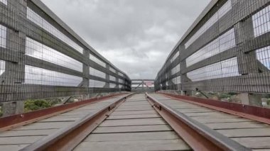 Demiryolu rayları ve bulutlu gökyüzü ile eski ahşap köprü