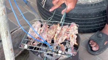 Izgara kullanarak balık içen bir adam. Kapat. 