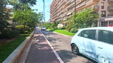 Cadde boyunca yeşil ağaçların büyüdüğü şehirde trafik vardı.