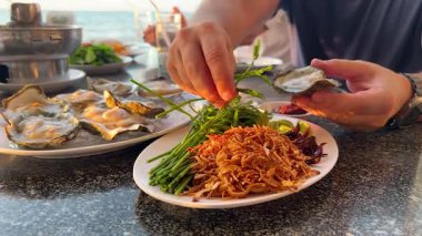 Eller taze malzemelerle deniz ürünleri yemeği hazırlıyor.