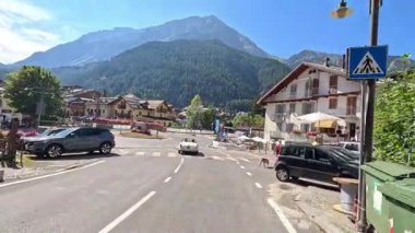 Bir araba pitoresk bir dağ kasabasından geçiyor.