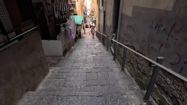 Dar bir sokakta yürüyen insanlar