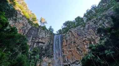 Şelale kayalık bir uçurumdan aşağı yuvarlanıyor.