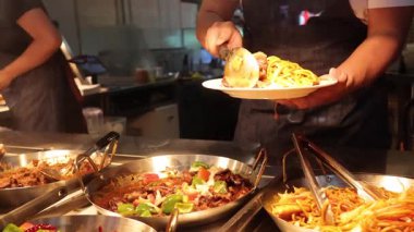 Aşçı markette yemek servisi yapıyor.