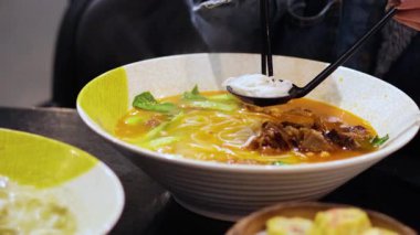 Erişte çorbası hazırlayan ve yiyen kişi.