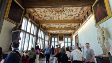 Uffizi Galerisi 'nin sanat sergilerini gezen turistler