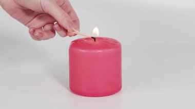 Bir kibritle pembe bir mum yakma dizisi