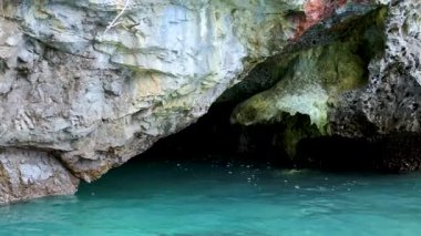 Dalgalar yavaşça kayalık sahil kayalıklarına çarpar