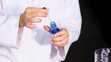 Bilim adamı deney için deney kabına boya ekliyor.