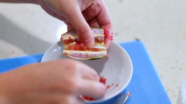 Mutfak tezgahındaki doğal ışıklandırmalı bir kaseye limon hamuru döken eller.