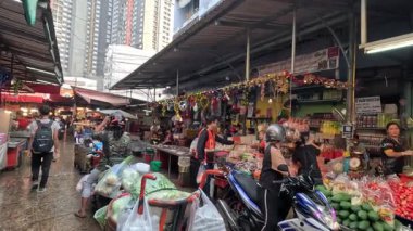 Kalabalık bir pazarda müşteriler ve satıcılar.