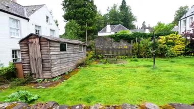 Kırsal kulübesi ve kulübesi olan yemyeşil bir bahçe.