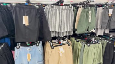 Bir mağazada çeşitli şortlar sergileniyor