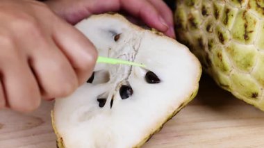 Elma dilimleyen ve kremalı elmadan tohum çıkaran eller.