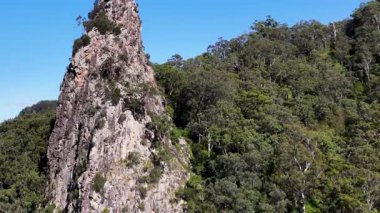 Nimbin, Avustralya 'da Nimbin, NSW, Avustralya' da açık mavi gökyüzü altında yemyeşil alanlara karşı engebeli Nimbin Kayalarını görüntüler.