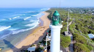 Point Lonsdale Deniz Feneri 'nin temiz gökyüzünün altında sahil ve okyanus manzaralı havadan çekilmiş görüntüleri.