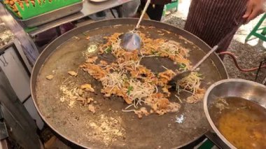 Büyük bir tavada erişte pişirip karıştırmak.