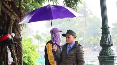 Yağmur sırasında iki kişi bir şemsiyeyi paylaşır