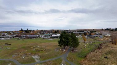 Hava görüntüleri Tekapo Gölü 'nü bulutlu gökyüzü altında yakalıyor, doğal manzaraları ve yerleşim yerlerini yumuşak kamera hareketleriyle gösteriyor.