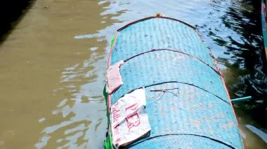 Geleneksel bir tekne, Khlong Lat Mayom Yüzen Piyasası 'nda, canlı renkler ve dingin hareketler sergiliyor.