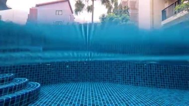 Sakin bir otel havuzuna yağmur yağıyor.