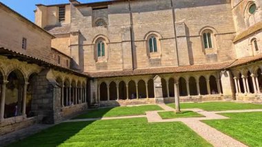 Taş mimarisi ve yeşilliği olan tarihi avlu.