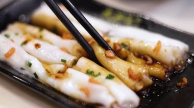 Çubuklar soslu erişteli pirinç rulosu kaldırıyor.