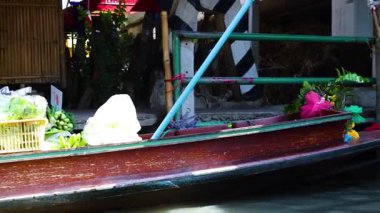 Canlı yüzen bir pazarda tekneler mal satıyor.